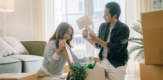 Couple unloading box in living room