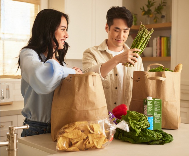 Couple unloading groceries together in their kitchen